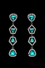 Image showing earrings with blue stones on the black 