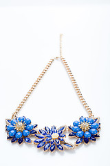 Image showing plastic necklace. three blue flower