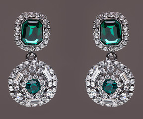 Image showing earrings with green stones on the gray