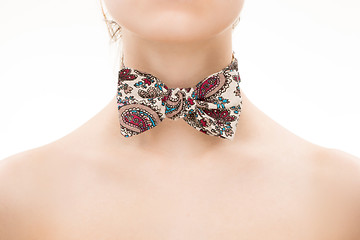 Image showing patterned tie bow on female neck. 