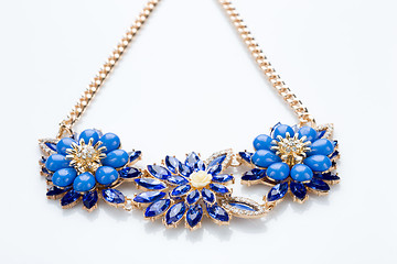 Image showing plastic necklace. three blue flower