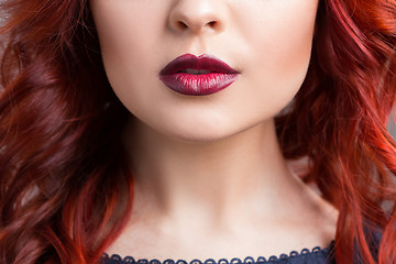 Image showing closeup cherry lips. girl with red hair. the lower part of the face. Fashion Girl Portrait.