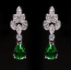 Image showing earrings with green stones on the black 