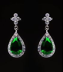 Image showing earrings with green stones on the black 