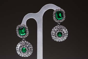 Image showing earrings with green stones on the black 