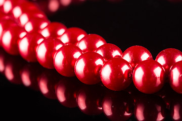 Image showing necklace of red pearls on black background