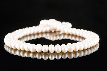 Image showing White pearls on  black  background. luxury necklace.