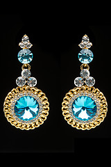 Image showing earrings with blue stones on the black 