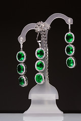 Image showing earrings with green stones on a stand