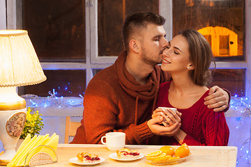 Image showing The  happy young couple with cups of tea 