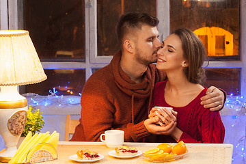 Image showing The  happy young couple with cups of tea 