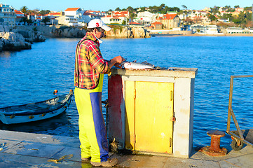 Image showing Fisherman cleaning fish