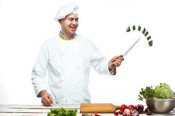 Image showing Chef cutting a green cucumber in his kitchen