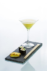 Image showing Yellow cocktail with a set of sushi on white background