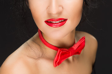 Image showing close-up of bright red lips, tied around his neck the bow tie