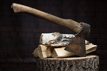 Image showing birch firewood, old rusty ax 