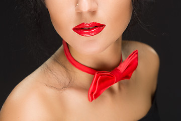 Image showing close-up of bright red lips, tied around his neck the bow tie