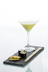 Image showing Yellow cocktail with a set of sushi on white background