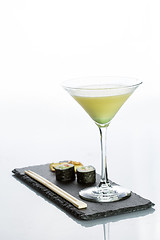 Image showing Yellow cocktail with a set of sushi on white background