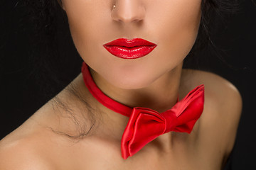 Image showing close-up of bright red lips, tied around his neck the bow tie