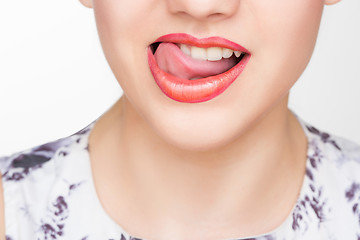 Image showing Licking lips. Close-up of young woman licking lips