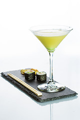 Image showing Yellow cocktail with a set of sushi on white background