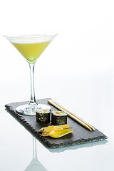 Image showing Yellow cocktail with a set of sushi on white background