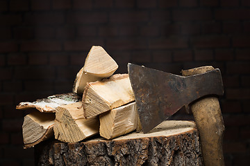 Image showing birch firewood, old rusty ax 