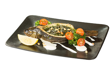 Image showing Stuffed seabass on a black plate 