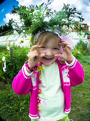 Image showing Blond baby girl in wreath in home garden