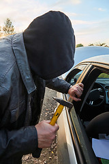 Image showing Hooligan breaking into car