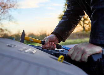 Image showing Hooligan breaking into car