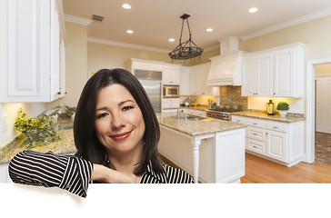 Image showing Hispanic Woman Leaning Against White In Custom Kitchen Interior