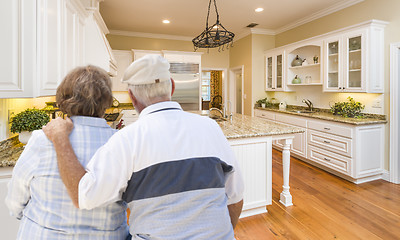 Image showing Senior Couple Looking Over Beautiful Custom Kitchen
