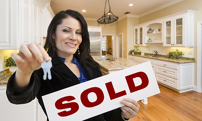 Image showing Hispanic Woman In Kitchen Holding House Keys and Sold Sign