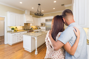 Image showing Young Hopeful Military Couple Looking At Custom Kitchen