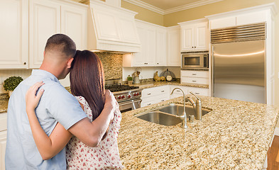 Image showing Young Hopeful Military Couple Looking At Custom Kitchen