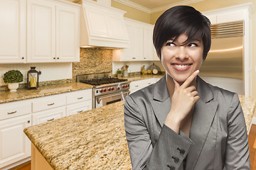 Image showing Mixed Race Woman Looking Back Over Shoulder Inside Custom Kitche