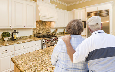 Image showing Senior Couple Looking Over Beautiful Custom Kitchen