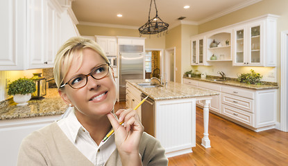 Image showing Daydreaming Woman with Pencil Inside Beautiful Custom Kitchen