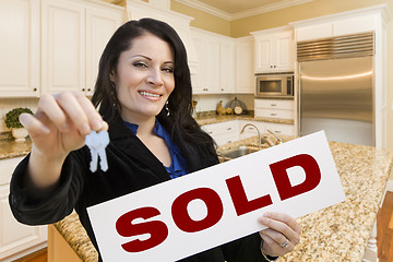 Image showing Hispanic Woman In Kitchen Holding House Keys and Sold Sign