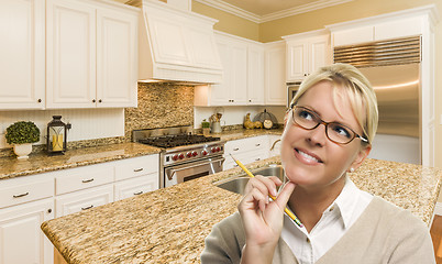 Image showing Daydreaming Woman with Pencil Inside Beautiful Custom Kitchen