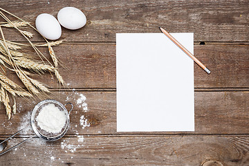 Image showing The flour  and eggs on an wooden background