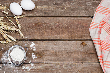 Image showing The flour  and eggs on an wooden background