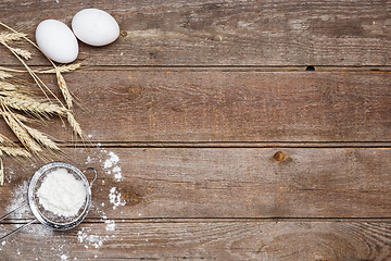 Image showing The flour  and eggs on an wooden background