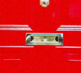 Image showing red handle in london antique brown door  rusty  brass nail and l