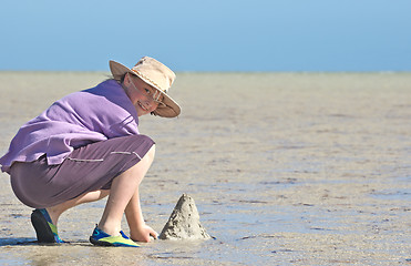 Image showing teenager making sandcastles on the beach