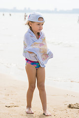 Image showing Frozen girl standing on the beach wrapped in a towel