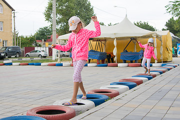 Image showing Two girls walking with interest on tires protecting circuit