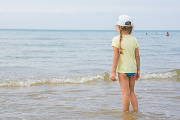 Image showing A girl stands on the shore and looks into the distance to the sea